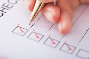 Hand filling out a checklist for fire inspection in Denver
